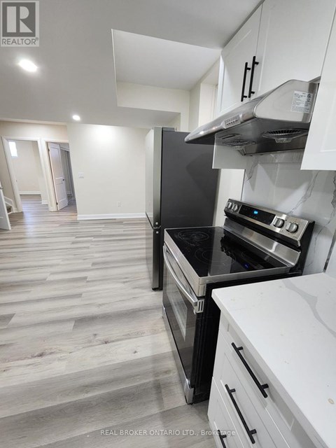 A modern kitchen with a stove top oven and white cabinets.