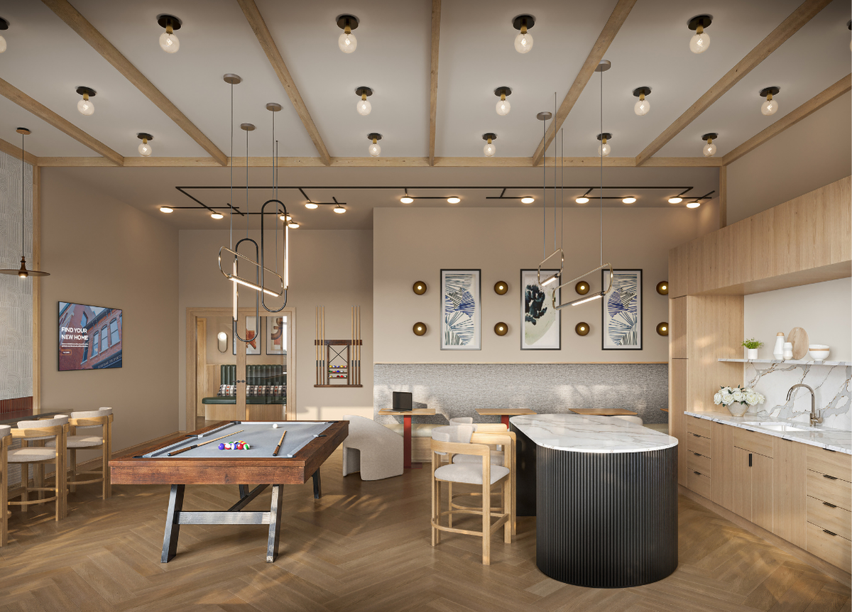 A billiard table is in the middle of a room with a kitchen area to the right.