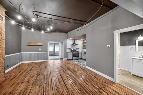 A room with wooden floors and a brick wall.