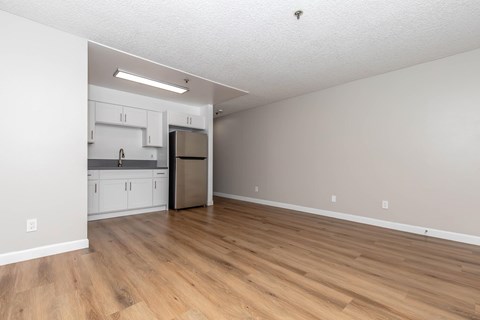 A kitchen with white cabinets and a stainless steel refrigerator.