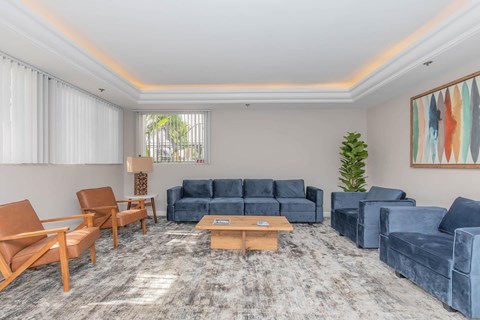 A living room with a grey carpet and furniture.