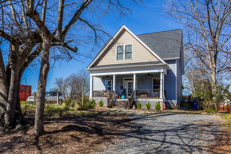 A house with a gravel driveway in front.