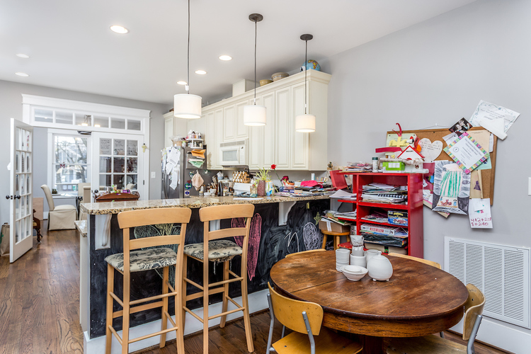 A kitchen with a table and chairs in front of a refrigerator.