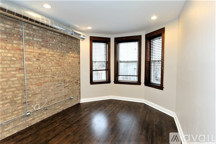 A room with a brick wall and wooden floors.