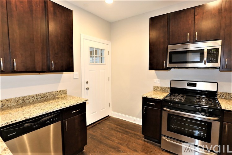 A kitchen with dark wood cabinets and stainless steel appliances.