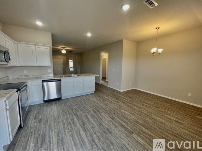 A kitchen with white cabinets and a dishwasher is available for rent.