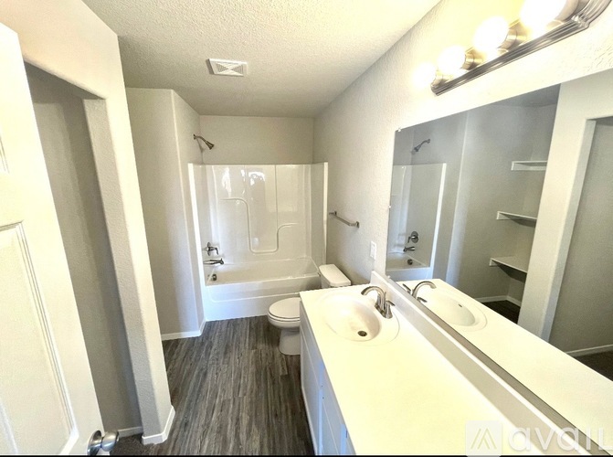 A bathroom with a toilet, sink, and mirror.