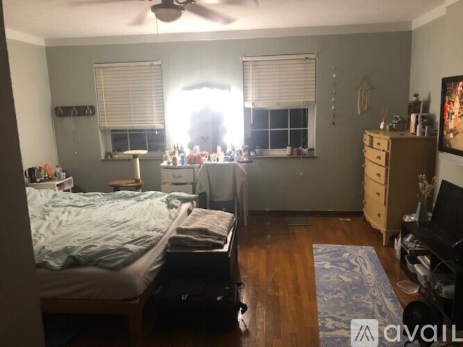 A bedroom with a bed, dresser, and window with blinds.