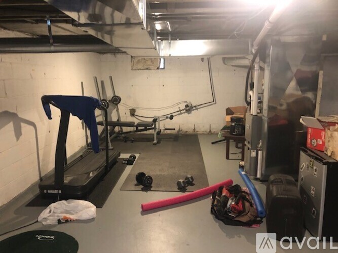 A gym with a treadmill, weights, and other equipment.