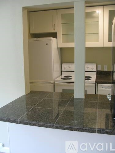 A kitchen with a granite counter top and white appliances.