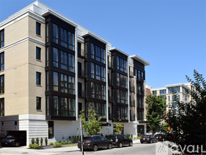 A modern building with a beige and black facade is shown.