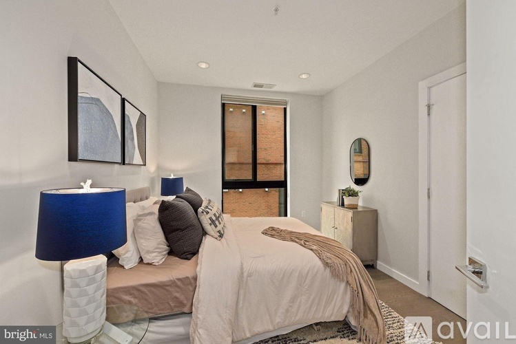 A bedroom with a bed, nightstand, and lamp.