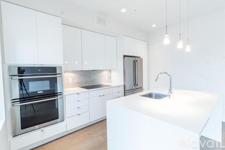 A modern kitchen with white cabinets and stainless steel appliances.