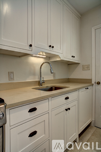 A kitchen with white cabinets and a sink.