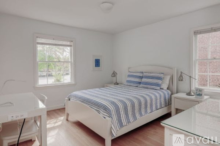 A bedroom with a bed, nightstand, and window.