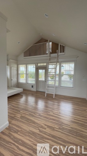 A room with wooden flooring and a window with blinds.