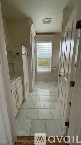 A hallway with tiled floors and white walls.
