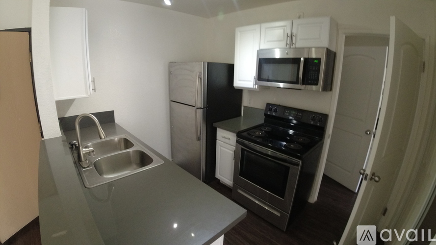 A kitchen with a sink, stove, and refrigerator.