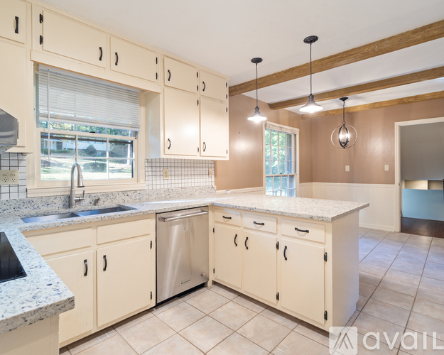 A kitchen with beige cabinets and a granite countertop.