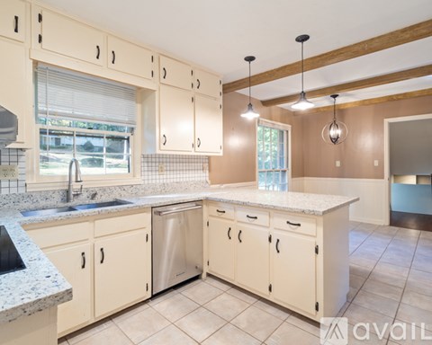 A kitchen with beige cabinets and a granite countertop.