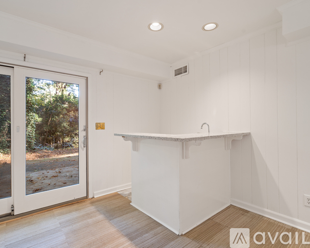 A white room with a window and a door leading outside.