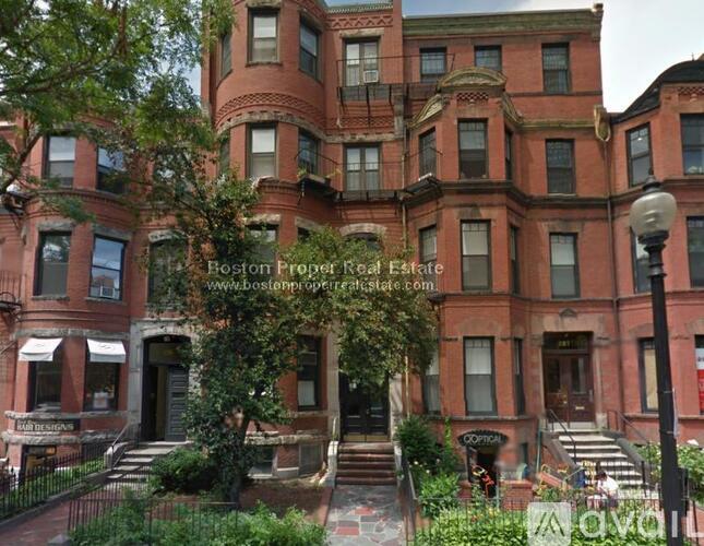 A large red brick building with a balcony on the second floor.