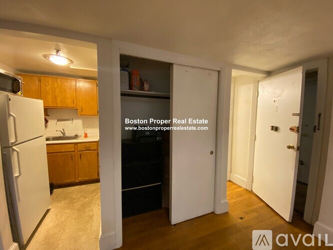 A kitchen with wooden cabinets and a white refrigerator is shown.