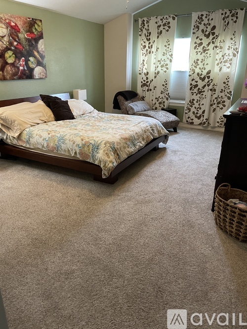A bedroom with a large bed and a smaller bed in the corner.