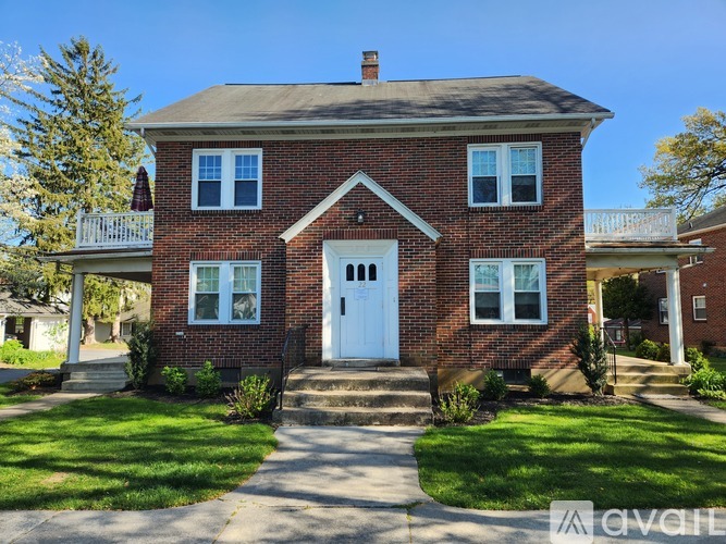 A red brick house with a white door and windows.