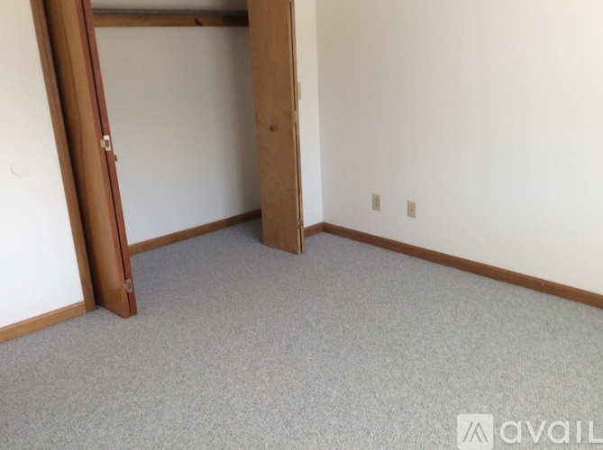 A room with a carpeted floor and a door.