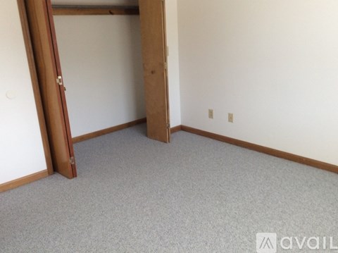 A room with a carpeted floor and a door.