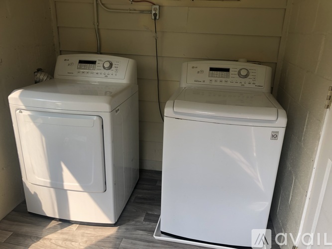 Two white front loading washing machines in a small room.