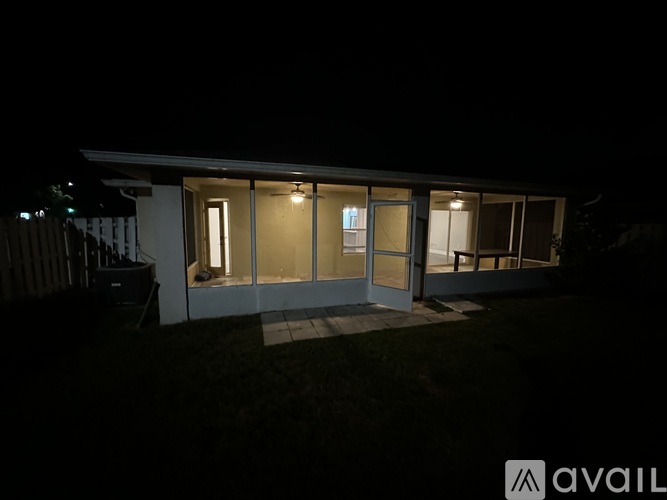 A house with a lit up sign that says "AVAIL" in the front yard.