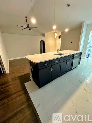 A modern kitchen with dark cabinets and a white countertop.