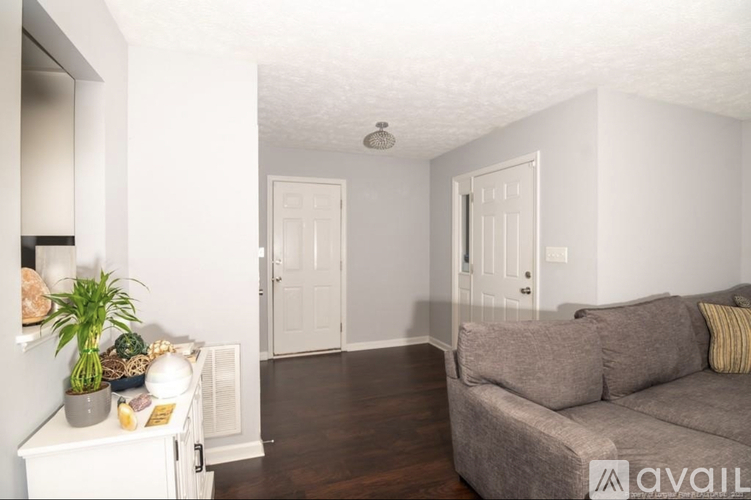 A living room with a grey couch and a white cabinet.
