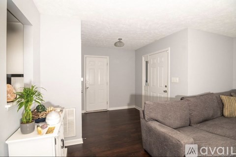 A living room with a grey couch and a white cabinet.