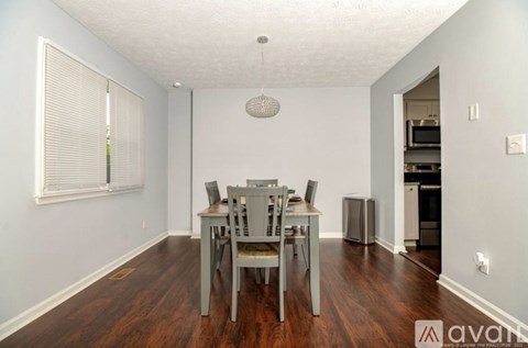 A dining room with a table and chairs.