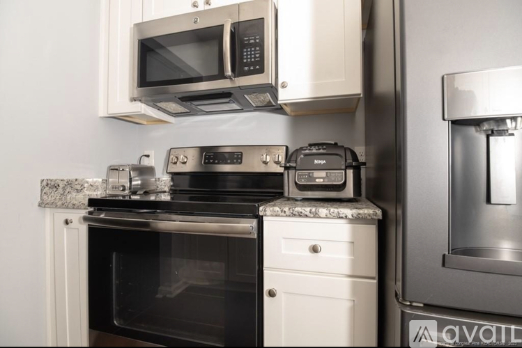 A modern kitchen with a black oven and white cabinets.