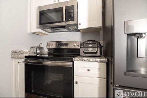 A modern kitchen with a black oven and white cabinets.