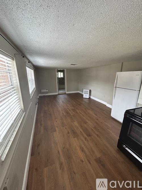 A kitchen with a white fridge and black oven.