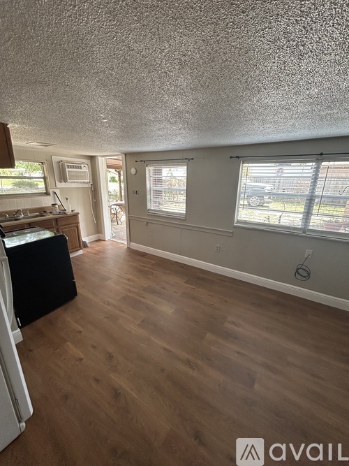A kitchen with a fridge and a dining table.