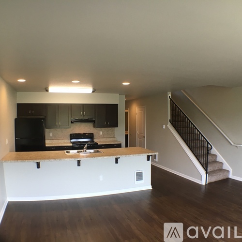 A kitchen with a black fridge and a black stove top oven.