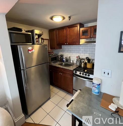 A kitchen with a stainless steel refrigerator and a stove top oven.