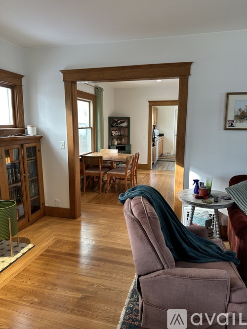 A living room with a brown chair and a green blanket on it.