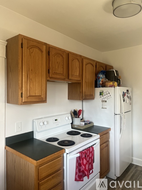 A kitchen with wooden cabinets and a white stove top oven.