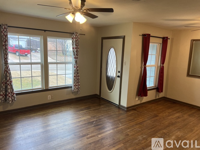 A room with a ceiling fan and a door with a window on the side.