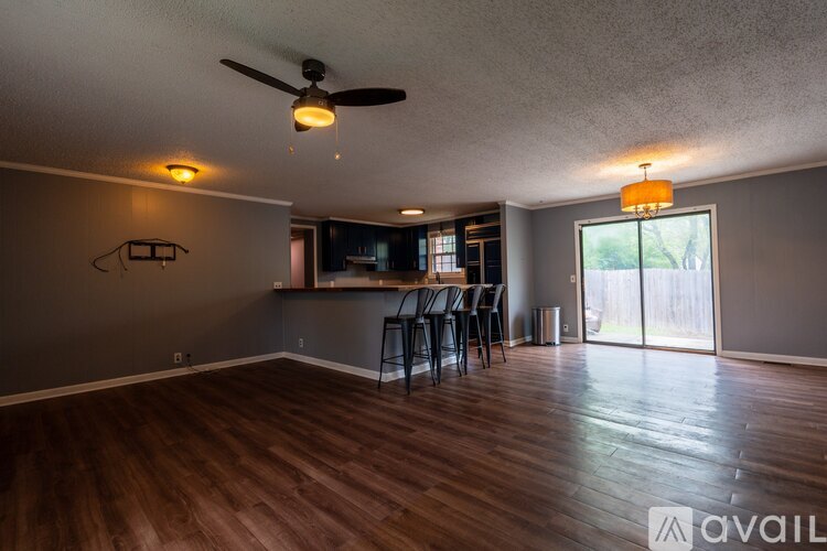 A room with a ceiling fan and wooden flooring.