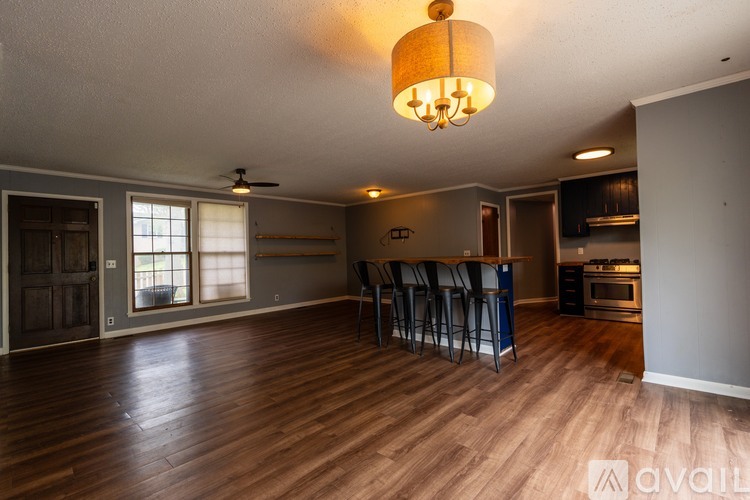 A living room with a bar area and a kitchen in the background.