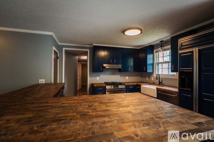 A kitchen with dark wood cabinets and a wooden floor.