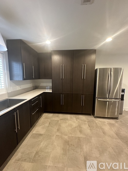 A kitchen with a refrigerator on the right side.